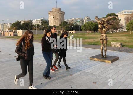 Thessaloniki, Greece, 20'th December 2018.  Young people walk pass a statue by Chinese artist Xu Hongfei in the northern Greek port city of Thessaloniki.  Fifteen statues made by Xu Hongfei are exhibited at the waterfront of Thessaloniki between December 17 and December 24, 2018, as part of artist's worldwide sculpture exhibition, which begins in Thessaloniki. Credit : Orhan Tsolak / Alamy Live News Stock Photo