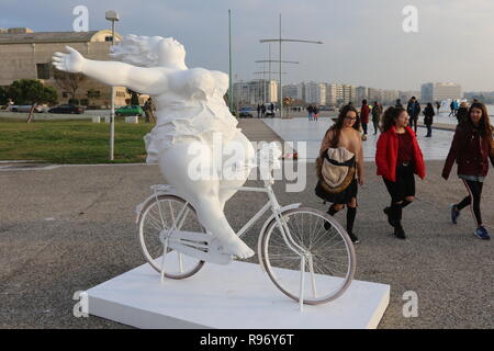 Thessaloniki, Greece, 20'th December 2018.  Young women walk pass a statue by Chinese artist Xu Hongfei in the northern Greek port city of Thessaloniki.  Fifteen statues made by Xu Hongfei are exhibited at the waterfront of Thessaloniki between December 17 and December 24, 2018, as part of artist's worldwide sculpture exhibition, which begins in Thessaloniki. Credit : Orhan Tsolak / Alamy Live News Stock Photo