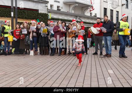Cork, Ireland, 20th December, 2018.   Cork City.  Carolers raising funds for Cork Simon on Patrick Street Today. Today saw Cork City fill with shoppers in the final few days before Christmas. Cafes and Resutraunts were filled. Shoppers Queued up outside business such as hairdressers and salons, and the streets were filled with a festive feeling as many carol groups were scatttered throughout the city. Credit: Damian Coleman/Alamy Live News. Stock Photo