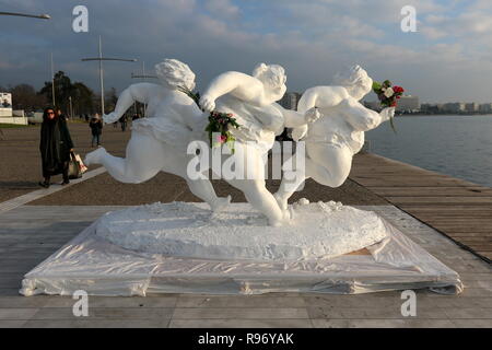 Thessaloniki, Greece, 20'th December 2018.  A woman walks pass a statue by Chinese artist Xu Hongfei in the northern Greek port city of Thessaloniki.  Fifteen statues made by Xu Hongfei are exhibited at the waterfront of Thessaloniki between December 17 and December 24, 2018, as part of artist's worldwide sculpture exhibition, which begins in Thessaloniki. Credit : Orhan Tsolak / Alamy Live News Stock Photo