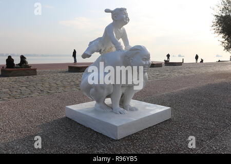 Thessaloniki, Greece, 20'th December 2018.  People walk around a statue by Chinese artist Xu Hongfei in the northern Greek port city of Thessaloniki.  Fifteen statues made by Xu Hongfei are exhibited at the waterfront of Thessaloniki between December 17 and December 24, 2018, as part of artist's worldwide sculpture exhibition, which begins in Thessaloniki. Credit : Orhan Tsolak / Alamy Live News Stock Photo