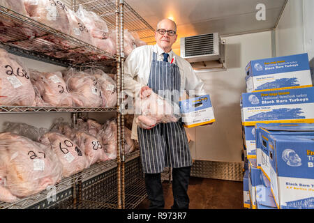 Willingham, Cambridgeshire, UK, 21st December 2018.  Butcher Steve Collett stands in a cold store full of turkeys preparing for the Christmas meat orders at the traditional village Highgate Butchers shop. Turkeys and beef and other products are stored in cold rooms then assembled into individual orders ready for the weekend rush when customers will collect for the festive season. Credit: Julian Eales/Alamy Live News Stock Photo