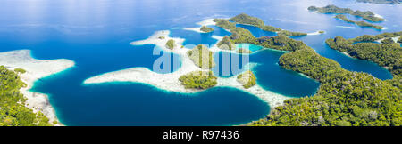 Remote limestone islands in Raja Ampat, Indonesia, are surrounded by healthy coral reefs. This region is known as the 'heart of the Coral Triangle.' Stock Photo