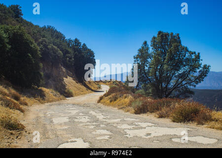 Rutted and pothole road leading into the mountains of southern California's Angeles National Forest. Stock Photo