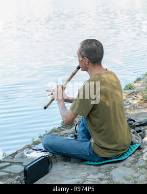 The flute player on the shores of South Lake, Hongcun Ancient Town, Lixian, Anhui, China Stock Photo