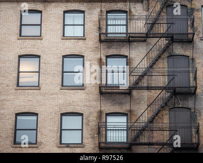 Fire escape stairs and ladder, in metal, on a typical North American old brick building from the Old Montreal, Quebec, Canada. These stairs, made for  Stock Photo