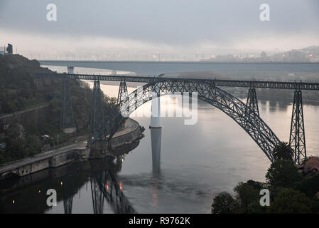 Distant view of the D. Maria Pia and Sao Joao Bridges, in Porto, Portugal during the morning hour. Cloudy sky. Stock Photo