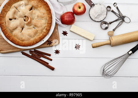 Homemade apple pie dessert and ingredients shot from overhead over a white wooden table top with room for copy space. Stock Photo