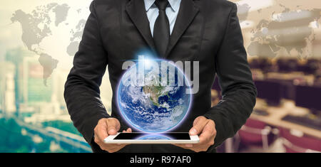 Businessman holding the tablet on Abstract blurred photo of empty computer room with earth and world map,Elements of this image furnished by NASA Stock Photo