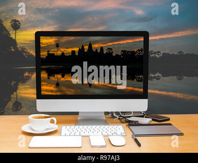 Conceptual image of a workspace with computer desktop on Silhouette of Angkor Wat sunrise at Siem Reap. Cambodia Stock Photo