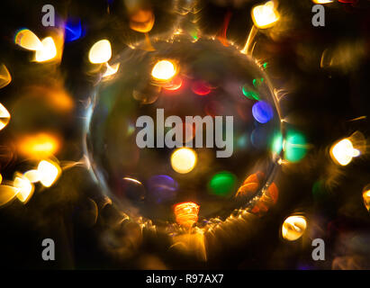 Glass Sphere Christmas Ornament is Lit by Multi-Colored Lights, Creating an Abstract Effect Stock Photo
