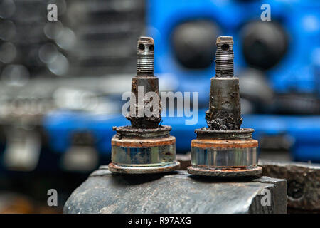 Close-up of heavily worn front ball joint on the table in a car repair shop, in the background tools for repairing cars. Stock Photo
