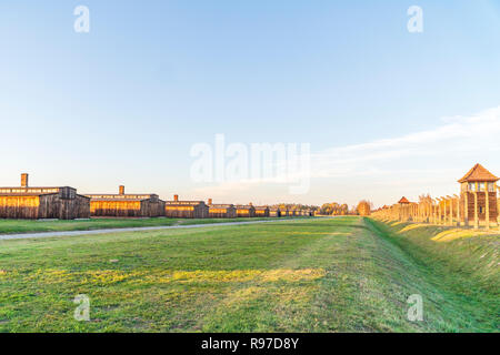 Fence surrounding plenty of wooden barracks in Auschwitz-Birkenau concentration camp, Poland Stock Photo