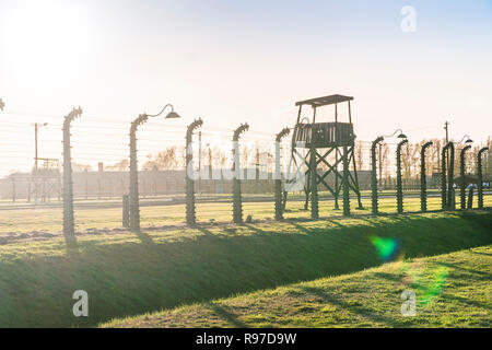 Barbed wire fence with watchtower surrounding concentration camp in Auschwitz Birkenau, Poland Stock Photo
