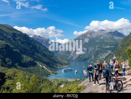 Tourists at the viewpoint overlooking the town of Geiranger and Geirangerfjord, Norway Stock Photo