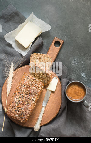 Loaf of rye bread with butter and cup of black coffee. Close up. Space for your text. Stock Photo