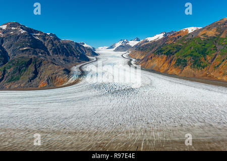 The majestic ice flow of the Salmon Glacier and the Boundary mountain range near the city of Hyder in Alaska, United States of America (USA). Stock Photo