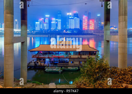 View of a bridge with a boat and Chongqing city buildings on the Yangtze River Stock Photo