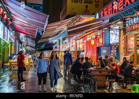 Night scene of a busy street with local restaurants and stalls in the downtown area of Jiefangbei, Chongqing Stock Photo