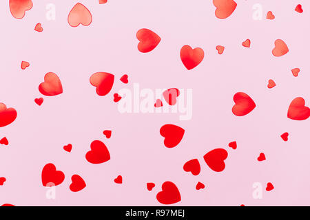 Beautiful heart shaped confetti on pastel pink background. Can be used as backdrop for your design with love concept. Stock Photo