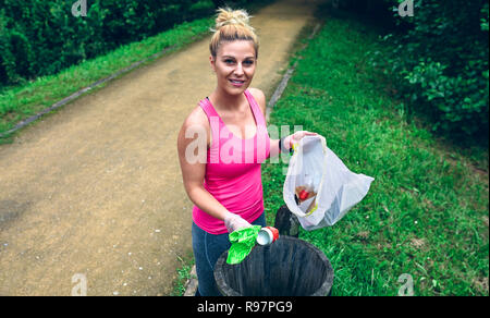 Woman throwing garbage after plogging Stock Photo