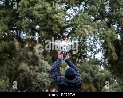 A drone landing in the hands of a man in the forest Stock Photo