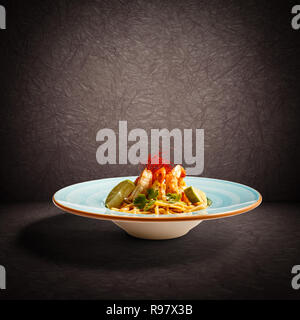Pasta linguine with green spices and flamed king shrimps Stock Photo