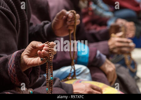 Buddhist beads in the hands of the tibetan pilgrims praying in Lamayuru monastery, Ladakh, India. Stock Photo