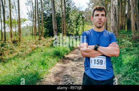 Male trail athlete posing with race number Stock Photo