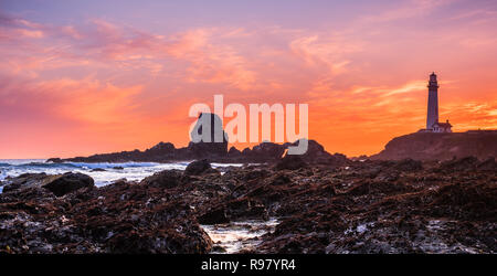 Rocky shoreline close to the Pigeon Point Lighthouse on the Pacific Ocean coastline, sunset landscape; Pescadero, California Stock Photo