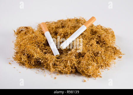 Dry cut tobacco and two hand made cigars on heap isolated on white background. Dried high quality tobacco for smoking and personal use. Close up Stock Photo