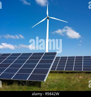 Renewable energy concept with view of a wind turbine and solar panels Stock Photo