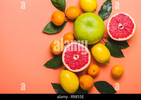 Multicolored grapefruits, lemons and tangerines. Living coral background. Color trend 2019 Stock Photo