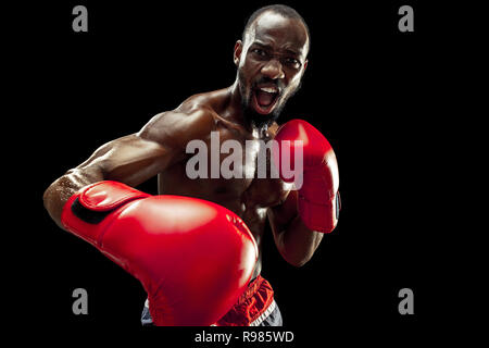 Hands of boxer over black background. Strength, attack and motion concept. Fit african american model in movement. Afro muscular athlete in sport uniform. Sporty man during boxing Stock Photo