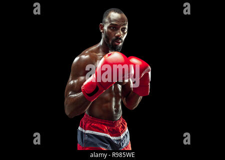 Hands of boxer over black background. Strength, attack and motion concept. Fit african american model in movement. Afro muscular athlete in sport uniform. Sporty man during boxing Stock Photo