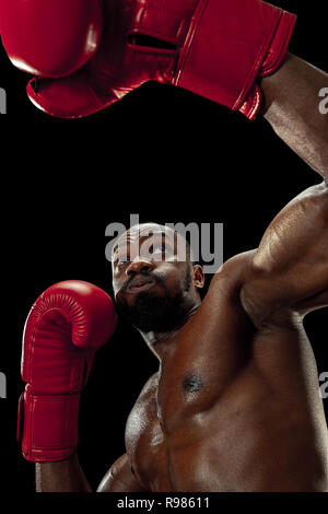 Hands of boxer over black background. Strength, attack and motion concept. Fit african american model in movement. Afro muscular athlete in sport uniform. Sporty man during boxing Stock Photo