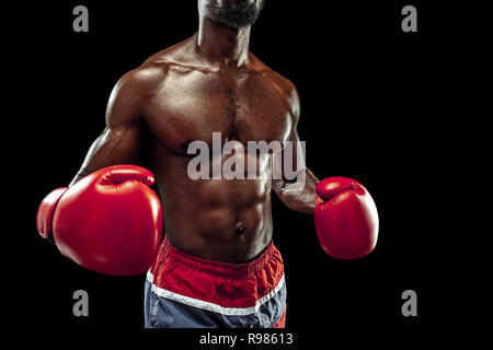 Hands of boxer over black background. Strength, attack and motion concept. Fit african american model in movement. Afro muscular athlete in sport uniform. Sporty man during boxing Stock Photo