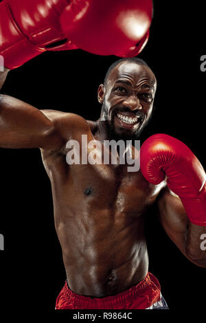 Hands of boxer over black background. Strength, attack and motion concept. Fit african american model in movement. Afro muscular athlete in sport uniform. Sporty man during boxing Stock Photo