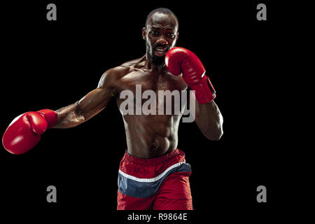 Hands of boxer over black background. Strength, attack and motion concept. Fit african american model in movement. Afro muscular athlete in sport uniform. Sporty man during boxing Stock Photo