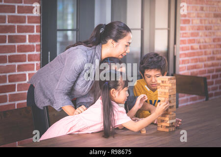 Children is building toy block tower with teacher Stock Photo