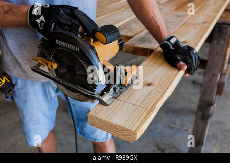 Man Using Circular Saw To Cut Wood Stock Photo