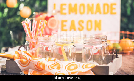 Raspberry lemonade garnished with fresh lemon and raspberries in drinking mason jars. Stock Photo