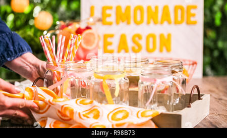 Raspberry lemonade garnished with fresh lemon and raspberries in drinking mason jars. Stock Photo