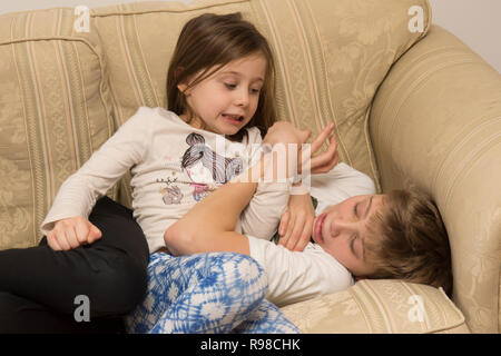 Sister teasing her younger brother Stock Photo - Alamy