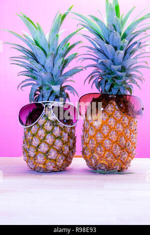 Pineapples with sunglasses sweet color on wooden plank. Stock Photo