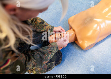 Paramedical soldier practices a medical training on a puppet Stock Photo