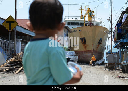 Residents move near KM Sabuk Nusantara which crashed ashore due to the tsunami in Wani, Donggala, Central Sulawesi, Saturday (November 3, 2018). Stock Photo