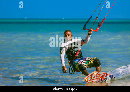 Egypt, Hurghada - 30 November, 2017: Close-up surfer with kite equipment standing on the surfboard. The Red sea shore. Unidentified Arab man surfing o Stock Photo