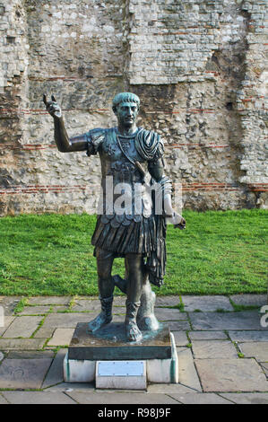 Statue of the Roman Emperor Trajan, outside a section of the Roman wall at Tower Hill, London UK Stock Photo