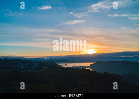 bay of the city of Puerto Montt from the heights at sunrise on a day partially covered with clouds Stock Photo